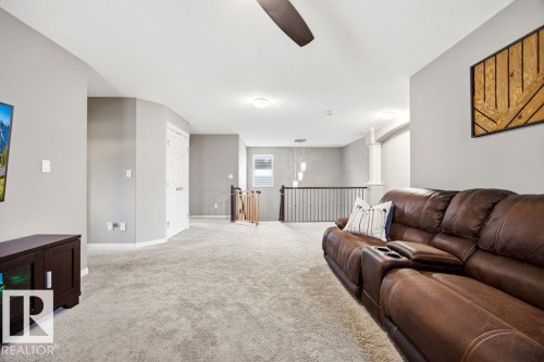 This spacious area features light gray walls and light-colored carpeting, creating an inviting atmosphere - 13024 206 Street, Edmonton, AB - Indoor