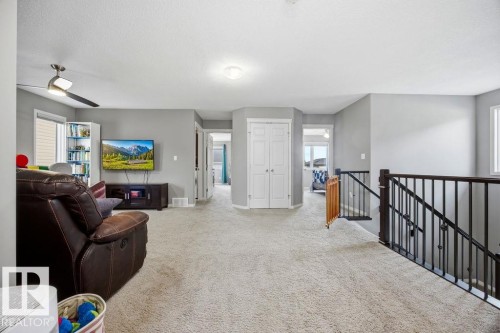 This property features an open area with light grey walls and carpeted flooring, providing a versatile space - 13024 206 Street, Edmonton, AB - Indoor