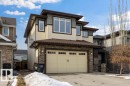 The property features a two-car garage with overhead lighting, a paved driveway, and stone accents - 13024 206 Street, Edmonton, AB  - Outdoor 