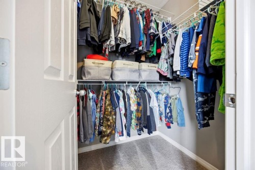 This closet features wire shelving and hanging rods providing storage solutions, with a carpeted floor - 13024 206 Street, Edmonton, AB - Indoor With Storage