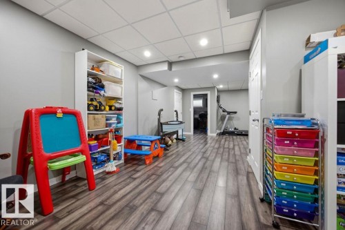 The property offers a versatile space with gray walls, recessed lighting, and durable wood-look flooring - 13024 206 Street, Edmonton, AB - Indoor
