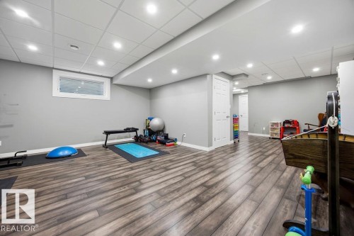 Expansive room featuring recessed lighting, durable wood-look flooring, and a window with blinds - 13024 206 Street, Edmonton, AB - Indoor Photo Showing Basement