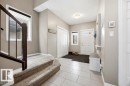 Inviting entryway featuring tile flooring, a carpeted staircase with dark wood railings, and a white front door with window panels - 13024 206 Street, Edmonton, AB  - Indoor Photo Showing Other Room 