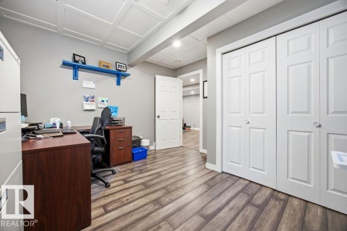 This versatile room features textured ceilings, light gray walls, and wood-look flooring - 13024 206 Street, Edmonton, AB - Indoor Photo Showing Office