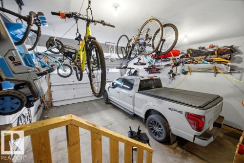 The property features a garage with a ceiling-mounted storage system and wall-mounted shelving - 13024 206 Street, Edmonton, AB - Indoor Photo Showing Garage