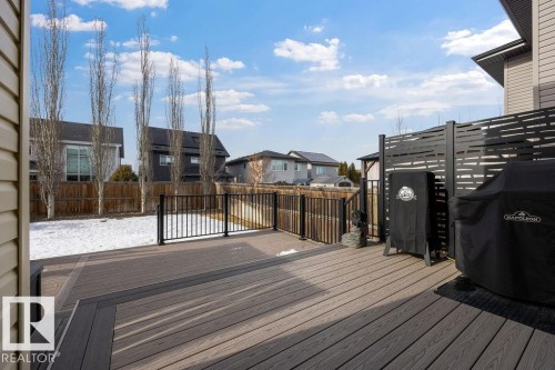 The property features an outdoor deck with composite decking, a black metal railing, and a decorative privacy screen - 13024 206 Street, Edmonton, AB - Outdoor With Deck Patio Veranda
