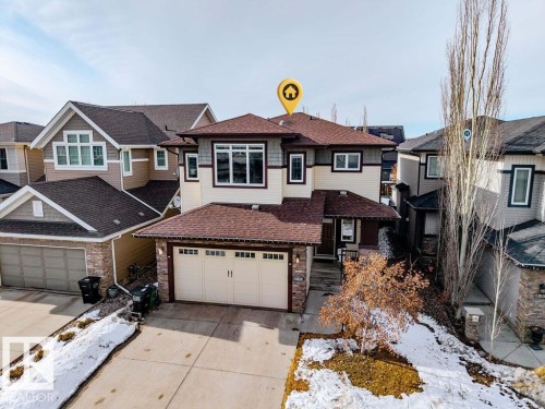 This property features a multi-level structure with a mix of siding and stone accents on its exterior - 13024 206 Street, Edmonton, AB - Outdoor With Facade