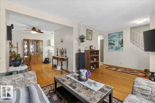 The property features an open living area with hardwood flooring, light-colored walls, and a ceiling fan in the dining space - 2 Mcleod Place, Edmonton, AB - Indoor Photo Showing Living Room