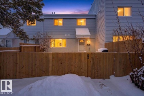 The property features light-colored horizontal siding and a prominent wooden fence - 2 Mcleod Place, Edmonton, AB - Outdoor With Exterior
