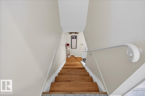 Staircase featuring hardwood steps and a white handrail, complemented by light-colored walls - 2 Mcleod Place, Edmonton, AB - Indoor Photo Showing Other Room