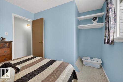 Bedroom with light blue walls, a window providing natural light, and a brown door - 2 Mcleod Place, Edmonton, AB - Indoor Photo Showing Bedroom