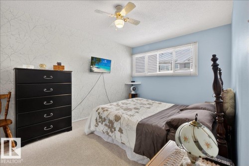 This room features a ceiling fan, a window with blinds, and light-colored carpeting - 2 Mcleod Place, Edmonton, AB - Indoor Photo Showing Bedroom
