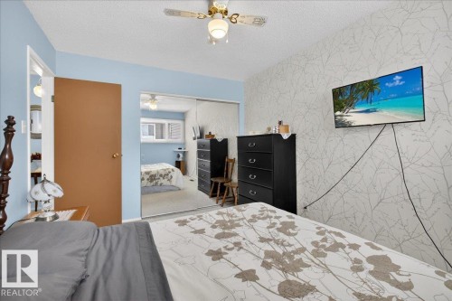 Bedroom featuring light blue walls, a ceiling fan with integrated lighting, and a wall-mounted television - 2 Mcleod Place, Edmonton, AB - Indoor Photo Showing Bedroom