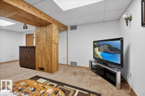 This versatile space features a dropped ceiling, carpet flooring, and a decorative wooden beam structure - 2 Mcleod Place, Edmonton, AB - Indoor