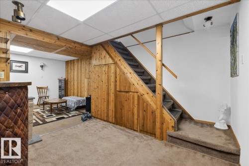 This versatile space features carpeting, a wooden staircase, and wood paneling - 2 Mcleod Place, Edmonton, AB - Indoor