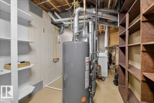 Utility area with a water heater, laundry appliance, and built-in shelving - 2 Mcleod Place, Edmonton, AB - Indoor Photo Showing Basement