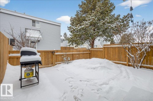 The property features a fenced yard with a natural wood fence and mature trees - 2 Mcleod Place, Edmonton, AB - Outdoor