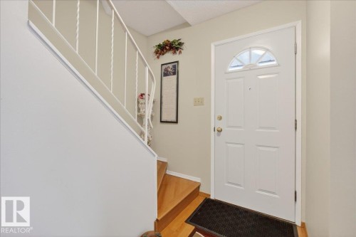 The property features hardwood stairs with a white banister, leading to an upper level - 2 Mcleod Place, Edmonton, AB - Indoor Photo Showing Other Room