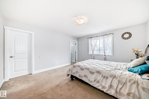 Bedroom featuring light gray walls, brown carpet, and a window providing natural light - 2 12042 101 Street, Edmonton, AB - Indoor Photo Showing Bedroom