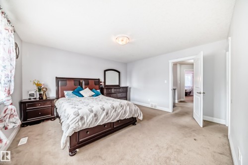 This room features light-colored walls and carpeting, a ceiling-mounted light fixture, and a doorway with a white door - 2 12042 101 Street, Edmonton, AB - Indoor Photo Showing Bedroom