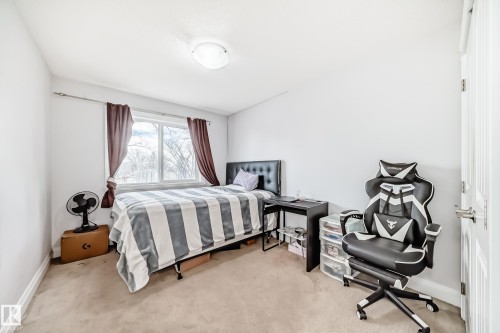 This room features light-colored carpeting and white walls, creating a bright and airy atmosphere - 2 12042 101 Street, Edmonton, AB - Indoor Photo Showing Bedroom