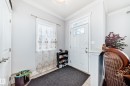Entryway with a white paneled door featuring a window panel, ceramic tile flooring, and a window with sheer curtains - 2 12042 101 Street, Edmonton, AB  - Indoor Photo Showing Other Room 