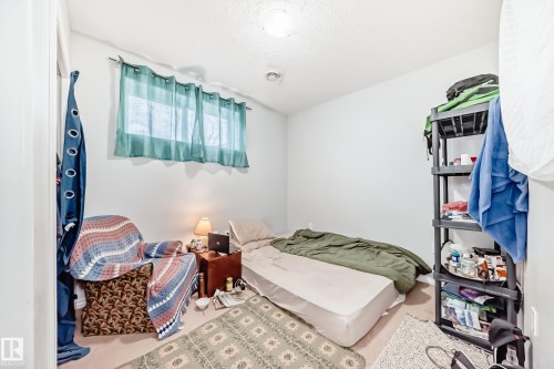 This room offers a window with curtains, white walls, and carpeted flooring - 2 12042 101 Street, Edmonton, AB - Indoor Photo Showing Bedroom