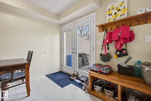 The property features a patio door with exterior views, a wooden storage bench with metal buckets, and a wooden wall shelf with hooks - 2006 Mill Woods Road E, Edmonton, AB - Indoor Photo Showing Other Room
