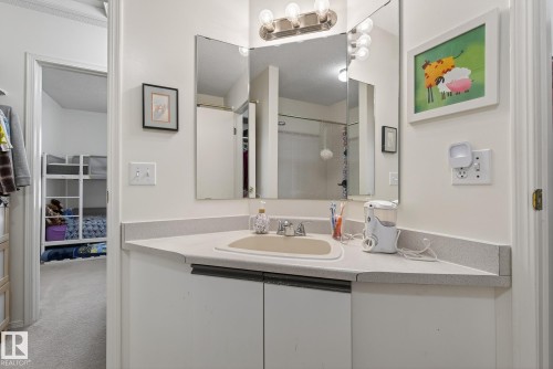 Bathroom featuring a vanity with a sink, mirrors, and wall-mounted lighting - 2006 Mill Woods Road E, Edmonton, AB - Indoor Photo Showing Bathroom