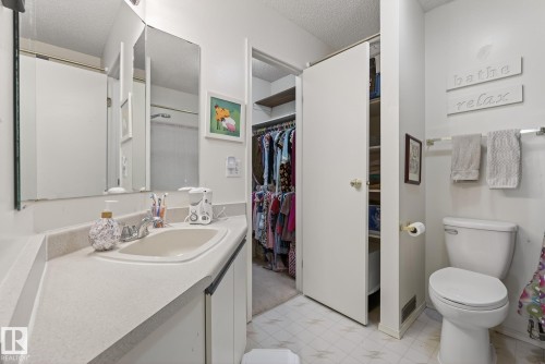 Bathroom featuring a vanity with an integrated sink, a mirror, and an adjacent toilet - 2006 Mill Woods Road E, Edmonton, AB - Indoor Photo Showing Bathroom