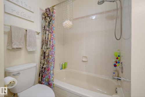 Bathroom with a toilet, bathtub, and tiled shower surround - 2006 Mill Woods Road E, Edmonton, AB - Indoor Photo Showing Bathroom