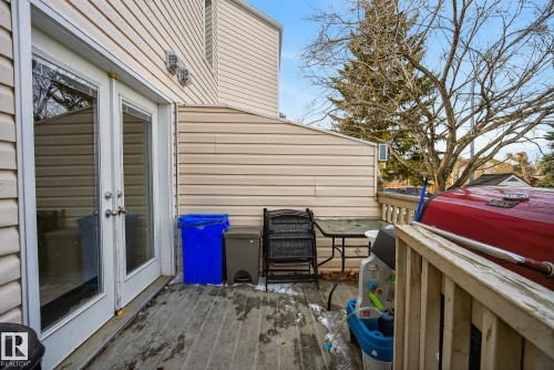 The property features a wooden deck with a wooden railing and siding exterior - 2006 Mill Woods Road E, Edmonton, AB - Outdoor With Exterior