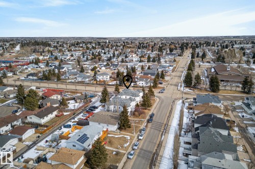 Aerial view of the property and its surrounding neighborhood, showcasing residential homes with sloped roofs, established trees, and paved roads - 2006 Mill Woods Road E, Edmonton, AB - Outdoor With View
