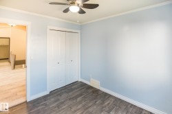 Room featuring dark wood-finish flooring, light blue walls, and white trim - 