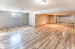 Spacious room featuring wood-finish flooring, recessed lighting, and a neutral color palette - 