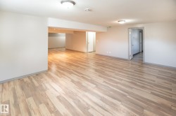 Spacious interior featuring wood-finish flooring, neutral wall tones, recessed lighting, and flush-mount ceiling fixtures - 