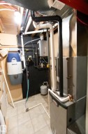 Mechanical room featuring a Lennox furnace, tankless water heater, and a water softener system - 