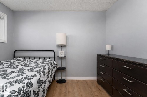The room features light gray walls, a window with white trim, and light wood flooring - 16131 109 Avenue, Edmonton, AB - Indoor Photo Showing Bedroom