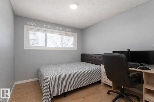 This room features light wood flooring, a window offering views of trees, and a ceiling light fixture - 16131 109 Avenue, Edmonton, AB - Indoor Photo Showing Other Room