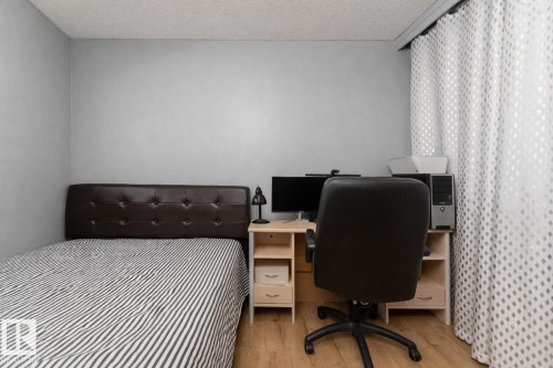 The property features light-colored flooring and walls, with a dark brown upholstered headboard - 16131 109 Avenue, Edmonton, AB - Indoor
