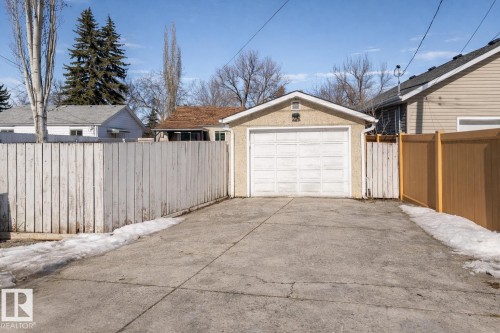 The property features a detached garage with a white overhead door and a concrete driveway - 16131 109 Avenue, Edmonton, AB - Outdoor With Exterior