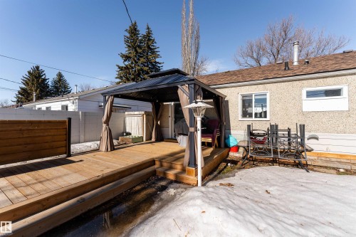 Exterior deck area featuring a gazebo with curtains, a privacy fence, and a portion of the property's exterior wall with windows - 16131 109 Avenue, Edmonton, AB - Outdoor