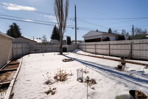 The property features a fenced backyard with a lawn and garden beds - 16131 109 Avenue, Edmonton, AB - Outdoor