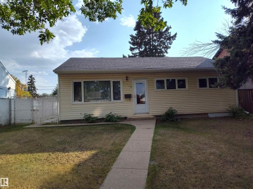 The property features a classic siding exterior, a well-maintained roof, and a paved walkway leading to the front entrance - 16165 109 Avenue Nw, Edmonton, AB - Outdoor