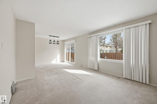 Spacious living room with large windows flooding in natural light - 221 Callingwood Place, Edmonton, AB - Indoor Photo Showing Other Room