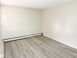 This room features light grey wood-look flooring and white painted walls, creating a bright and neutral aesthetic - 