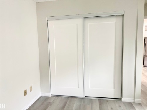 Closet with white sliding doors and light-colored flooring - 307 1620 48 Street, Edmonton, AB - Indoor Photo Showing Other Room