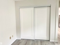 Closet with white sliding doors and light-colored flooring - 