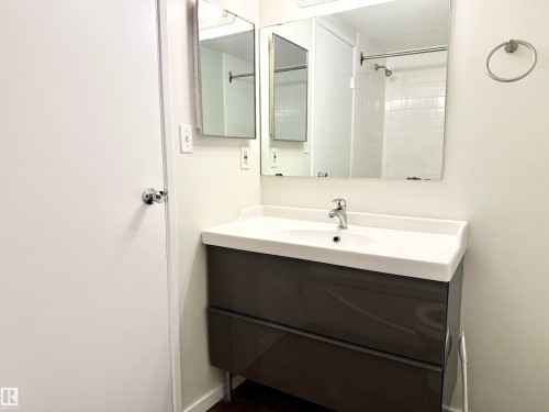 Bathroom vanity featuring a white sink basin and a dark gray cabinet with two drawers - 307 1620 48 Street, Edmonton, AB - Indoor Photo Showing Bathroom