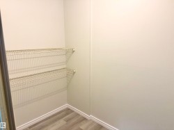 This closet provides convenient storage with two tiers of wire shelving and a light-toned wood-style floor - 